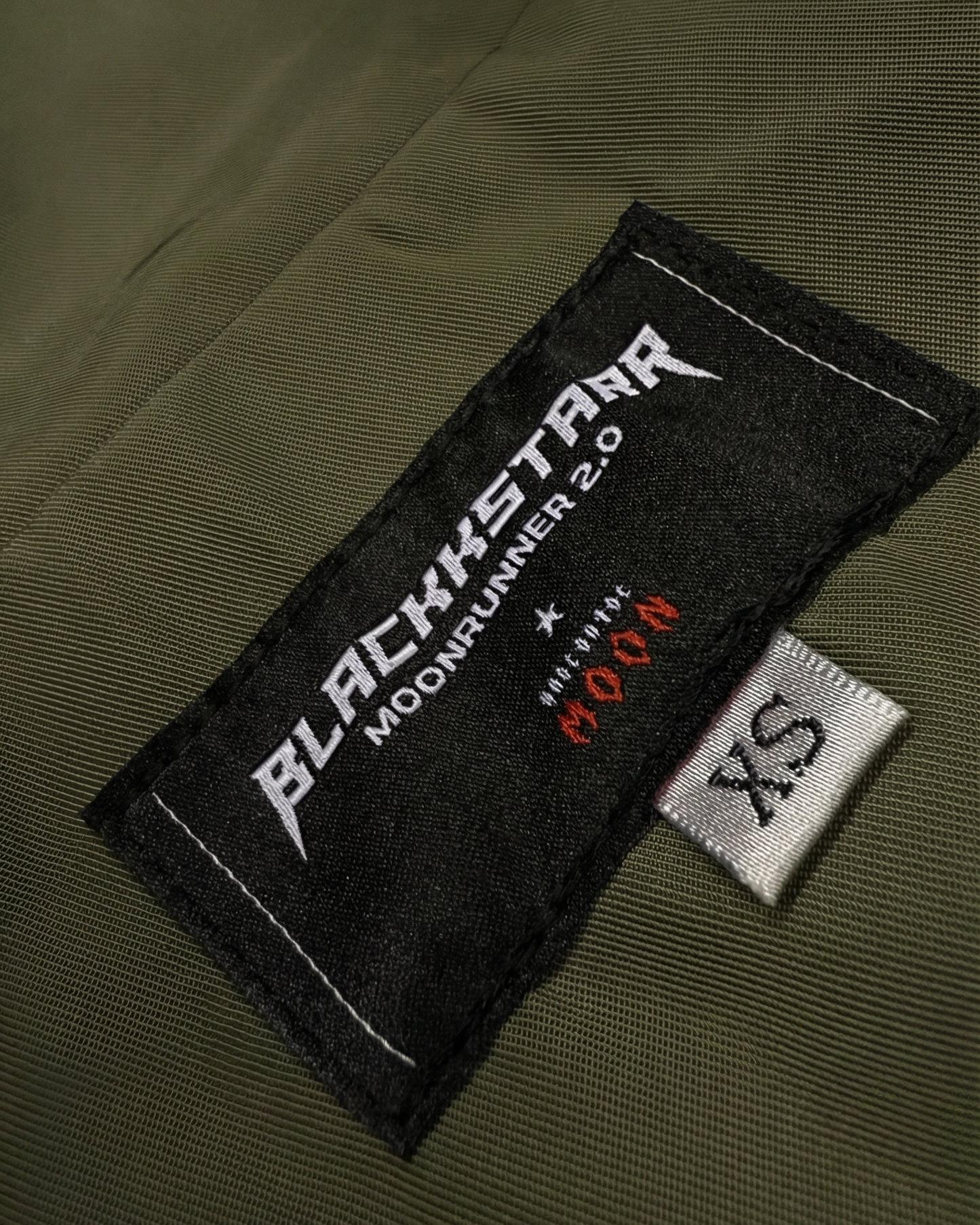 Green jacket with Blackstar label and size tag on a white background