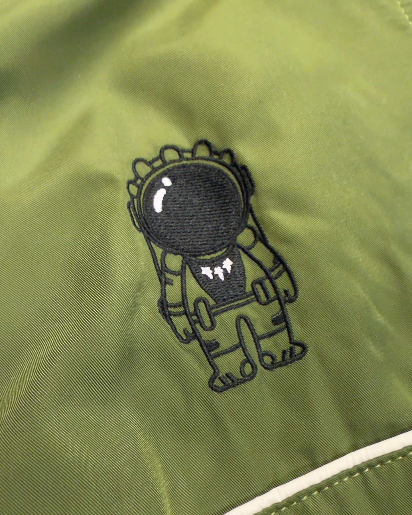 Black embroidered character on a green jacket