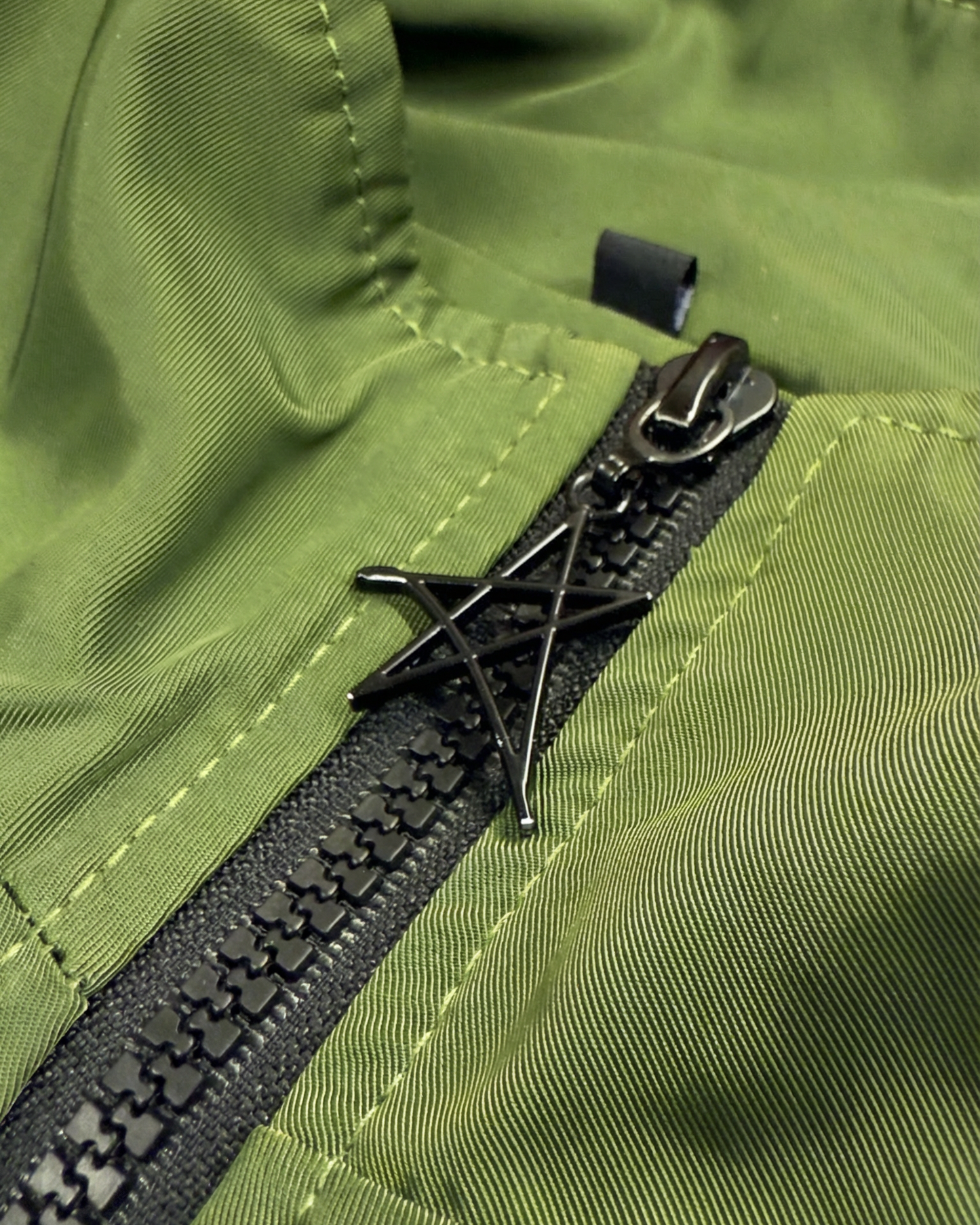 Close-up of a green jacket with a black zipper