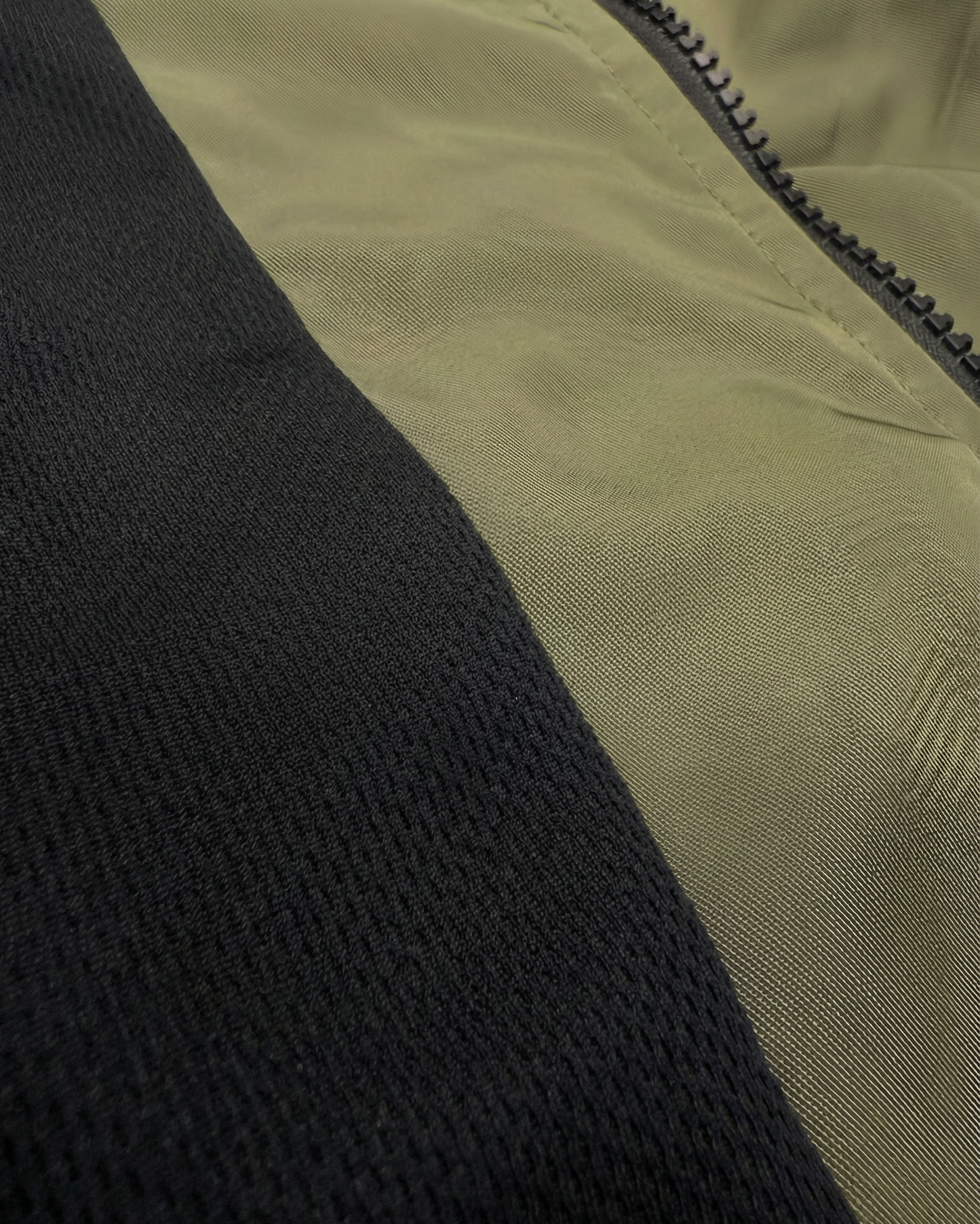 Close-up of a black and beige fabric with a zipper detail