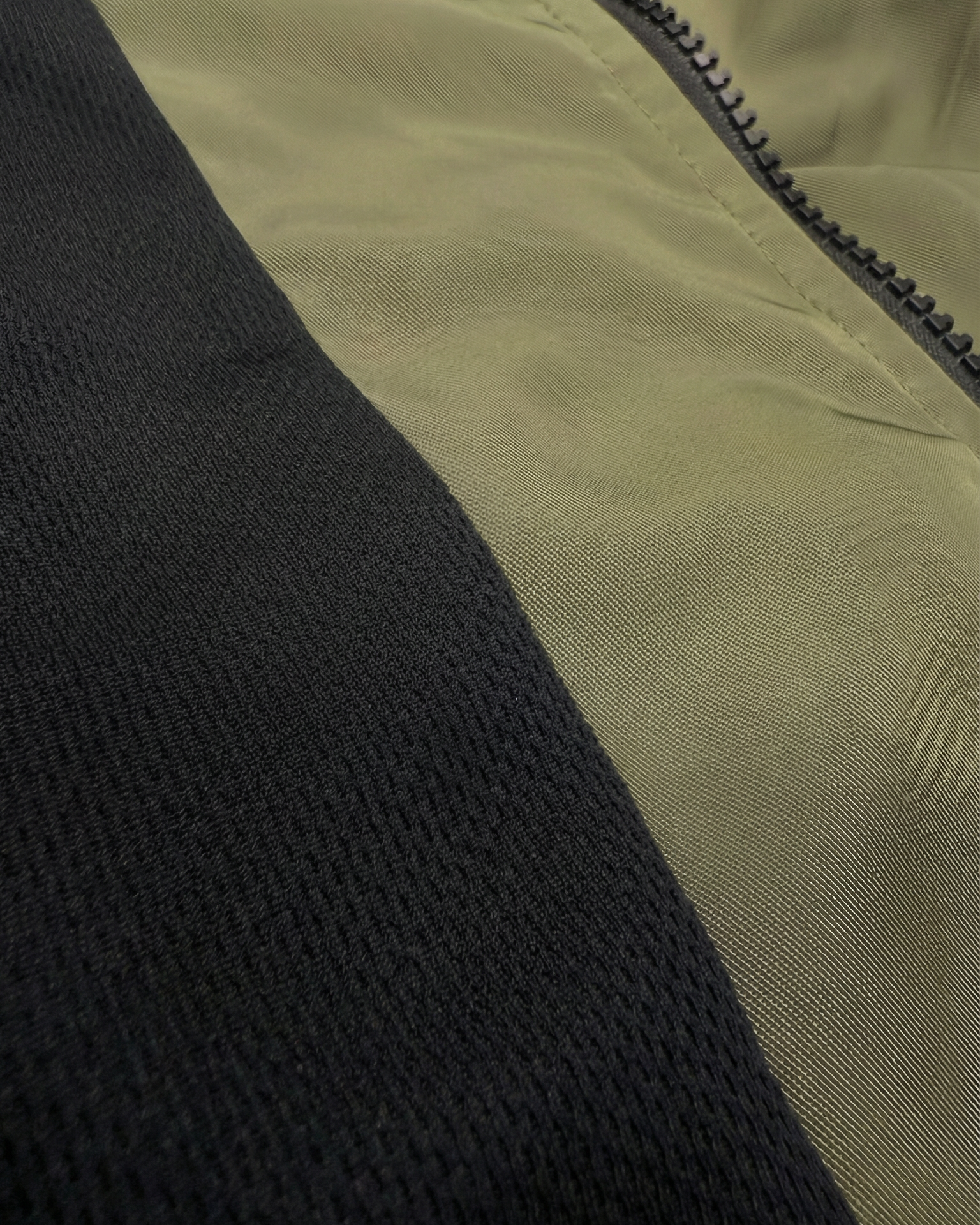 Close-up of a black and beige fabric with a zipper detail
